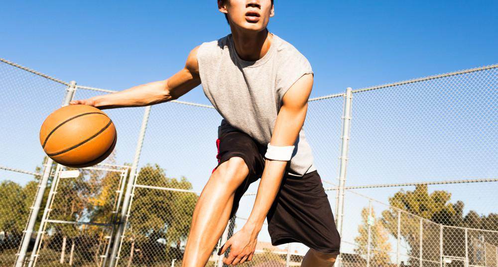 Young athlete playing basketball, potential for sports injuries.